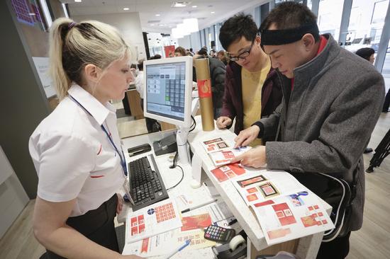 人们在一家邮局购买中国鸡年生肖邮品