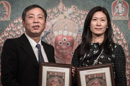    刘益谦与王薇从佳士得手中接受之前以创纪录价格拍下的西藏挂毯鉴定书。图片：Phillipe Lopez, courtesy AFP.