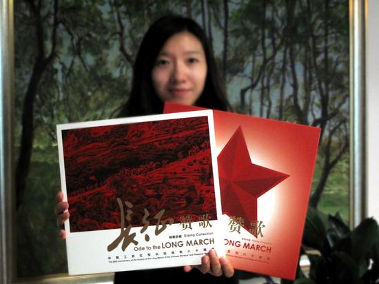 工作人员展示《长征赞歌》中国工农红军长征胜利八十周年邮票珍藏